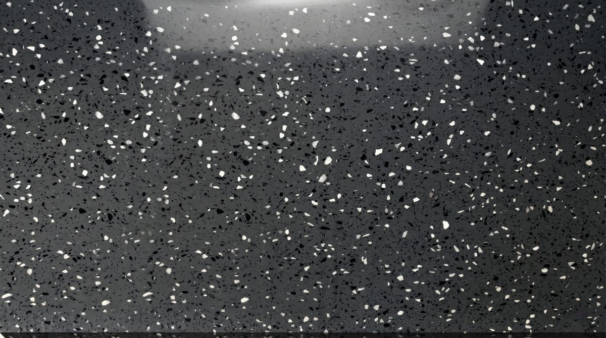 Close-up texture of charcoal grey artificial marble with chip particles