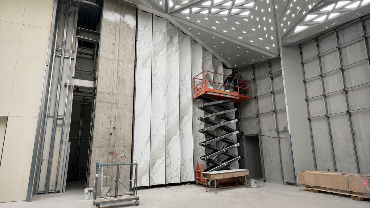 Polished white marble-look curved wall panels with grey veining in a commercial interior