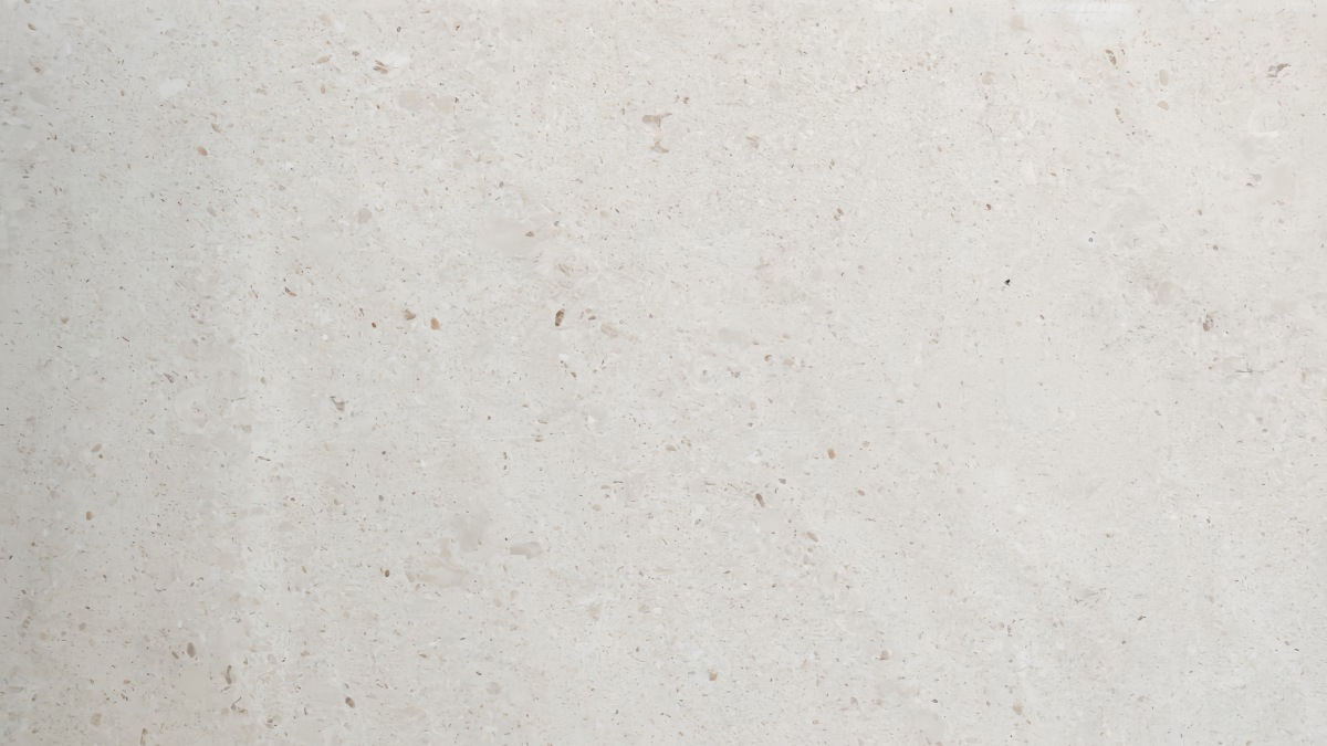 Close-up of cream limestone with fossil particles small pores and matte surface