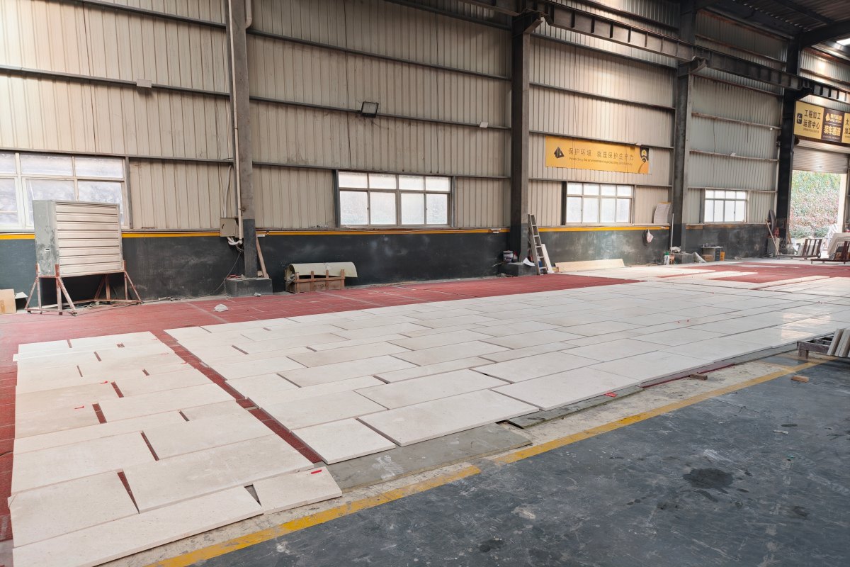 Cut-to-size Cotswold Cream limestone panels arranged before packing, showing controlled sizes, warm cream beige color, fine fossil particles, and matte natural surface